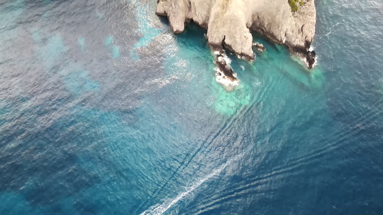 Aerial drone view of the Ionian Sea coast of Zakynthos, Greece. Rocky ridge with vegetation, blue water