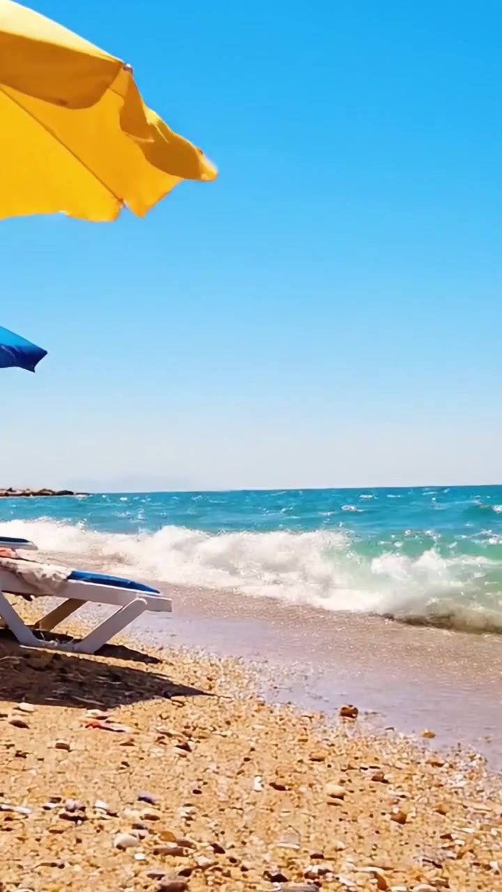 Una Tranquilla Scena da Spiaggia con Ombrelloni Colorati e Tesori a Conchiglia su una Costa Assolata Sotto un Cielo Azzurro Limpido e Dolci Onde dell'Oceano