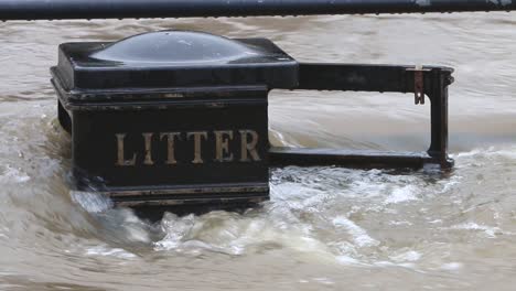 close up of flood water from the river severn flowing around a litter bin at bewdley