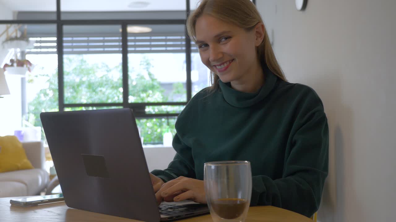 Women using her Laptop and Smiling to the Camera