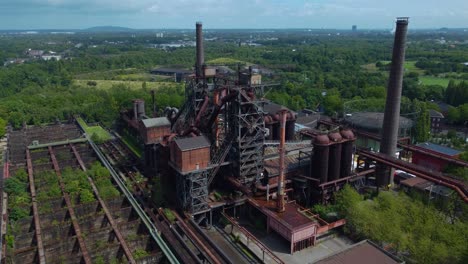 industrial plant with a large number of pipes and other machinery in the foreground captures both industry and nature in one shot showing how they can coexist together harmoniously cloudy horizon