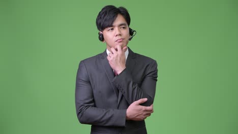 젊은 잘생긴 아시아 사업가 콜 센터 대표로 일하고 있습니다.