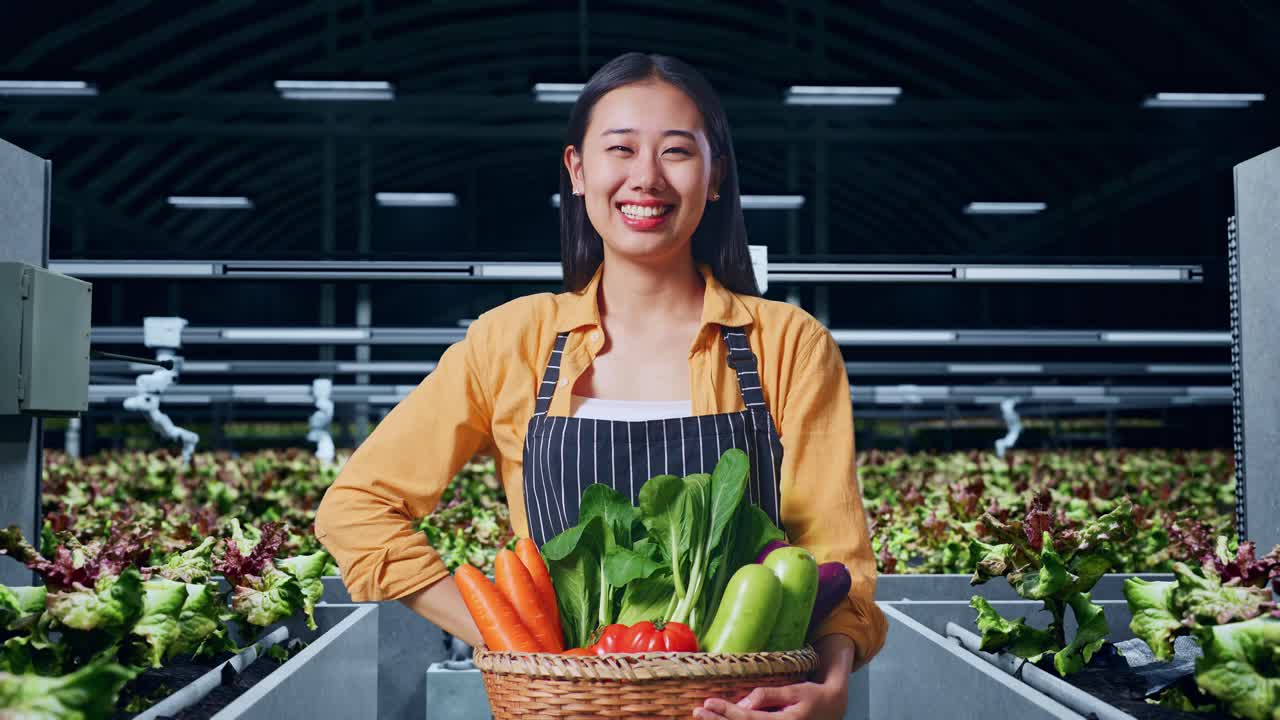 행복 한 여자 농부 는 온실 에서 신선 한 농산물 의 바구니 를 들고 있다