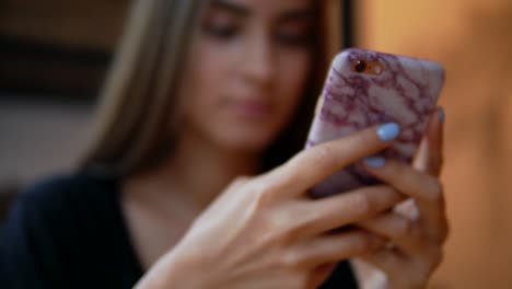 Vista-De-Cerca-De-Una-Joven-Atractiva-Con-Maquillaje-Natural-Usando-Su-Teléfono-Móvil-En-La-Toma-De-Café.-Uso-De-Dispositivos-Modernos