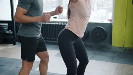 personal trainer guiding woman during barbell squat workout