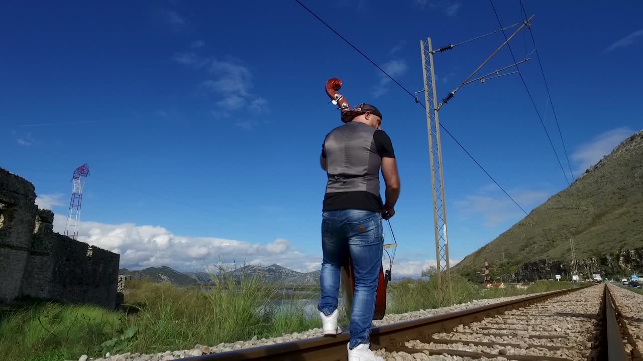 bajista actuando en las vías del tren