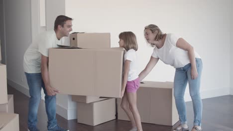 padre y hija alegres llevando una caja de dibujos animados