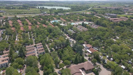 Drone-Dolly-Encima-De-Los-Condominios-Y-árboles-Del-Camping-Bella-Italia-En-El-Lago-De-Garda,-Italia