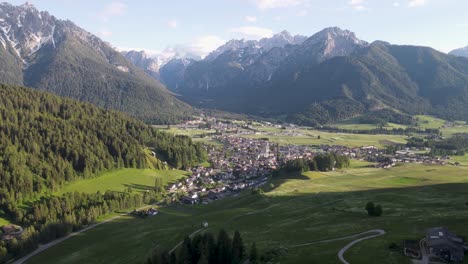 una toma aérea de la pequeña ciudad montañosa de toblach que se encuentra enclavada en las montañas dolomitas