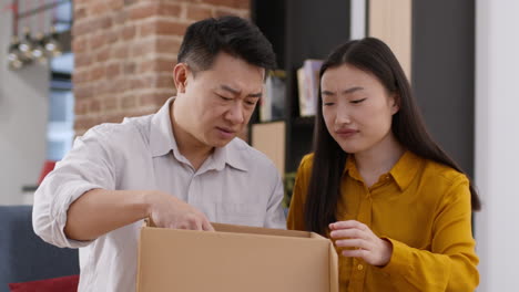 couple disagrees while unpacking a box
