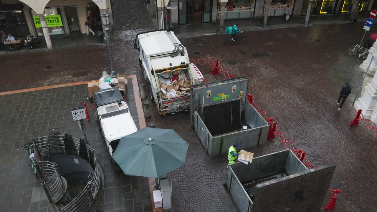 Garbage collector picking up trash in city in Italy