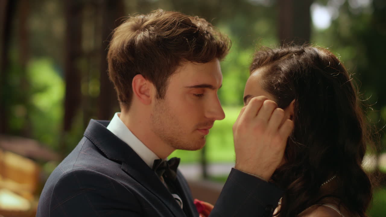 감각적인 남녀가 야외에서 포즈를 취하고 있다. 부부는 공원에서 부드럽게 포옹하고 있다.