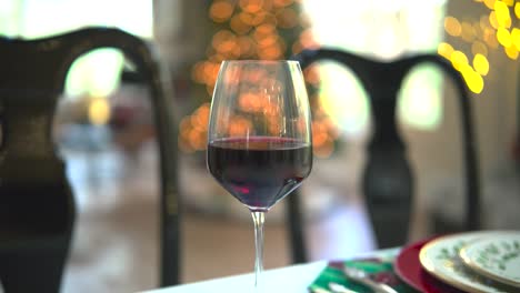 a sliding shot captures the allure of a red wine glass against a mesmerizing bokeh backdrop, a toast to sophistication