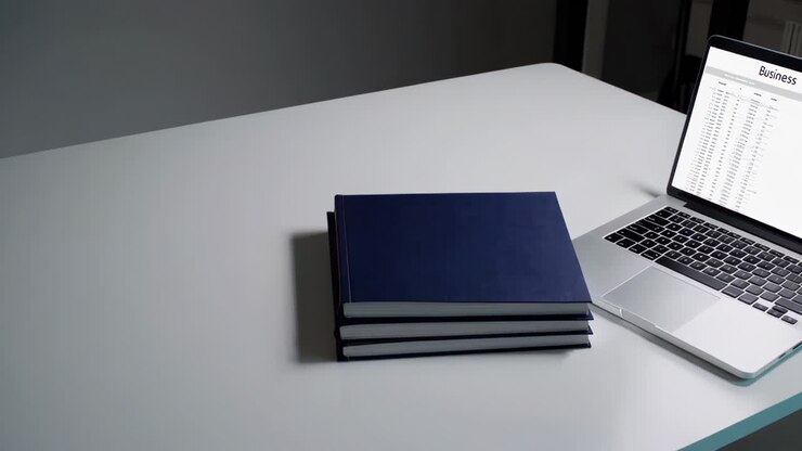 Moderní pracovní prostor s notebookem a knihami