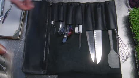 chef opens rolling knife roll