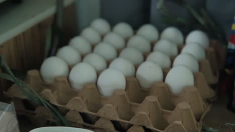static shot of eggs being taken out of egg tray for storage.