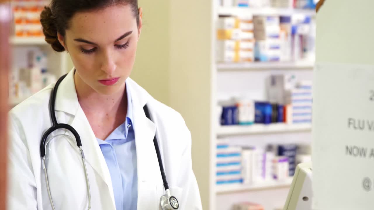 약사 가 컴퓨터 에서 처방전 기록 을 작성 하는 것