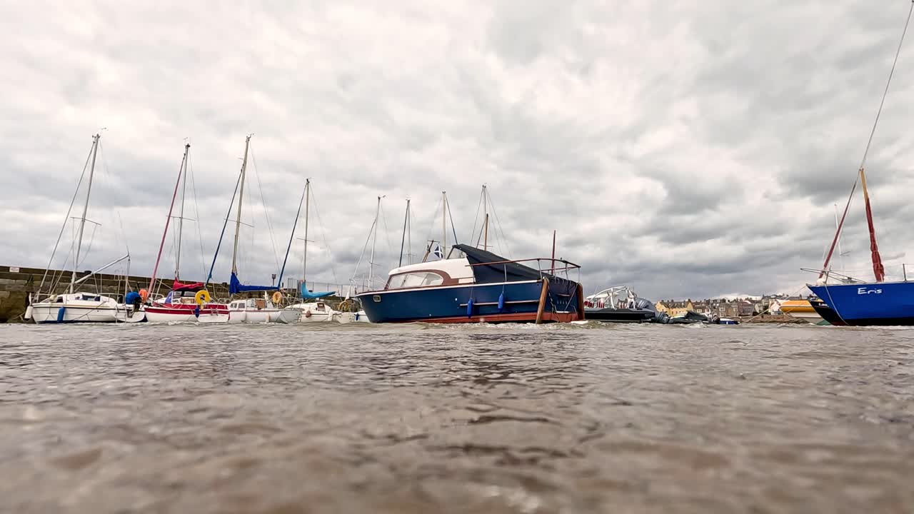 las olas mueven suavemente los barcos en el puerto escocés.