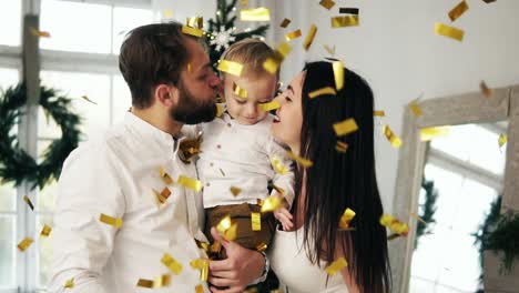 Familia-Joven-Con-Su-Pequeño-Y-Lindo-Niño-Entusiasmado-Con-Confeti-Brillante-Cayendo-Por-Todas-Partes-Celebrando-La-Navidad-En