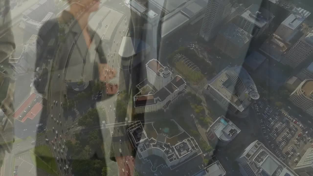 도시 풍경의 공중 전망에 맞서 손을 흔드는 사업가들의 중간 섹션의 디지털 구성