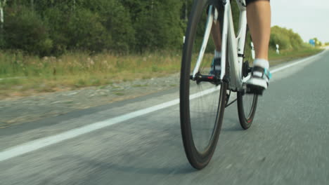 sporty woman in helmet riding bicycle on road