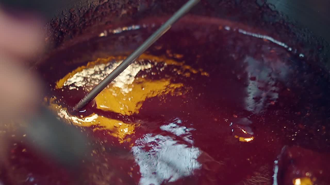 un pasticcere prepara caramello di bacche in una padella di metallo
