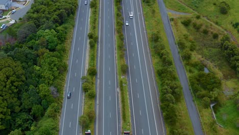 Autos,-Die-Auf-Der-Landstraße-Fahren,-Die-Im-Sommer-In-Byron-Bay,-Australien,-An-üppigen-Grünen-Feldern-Vorbeifährt