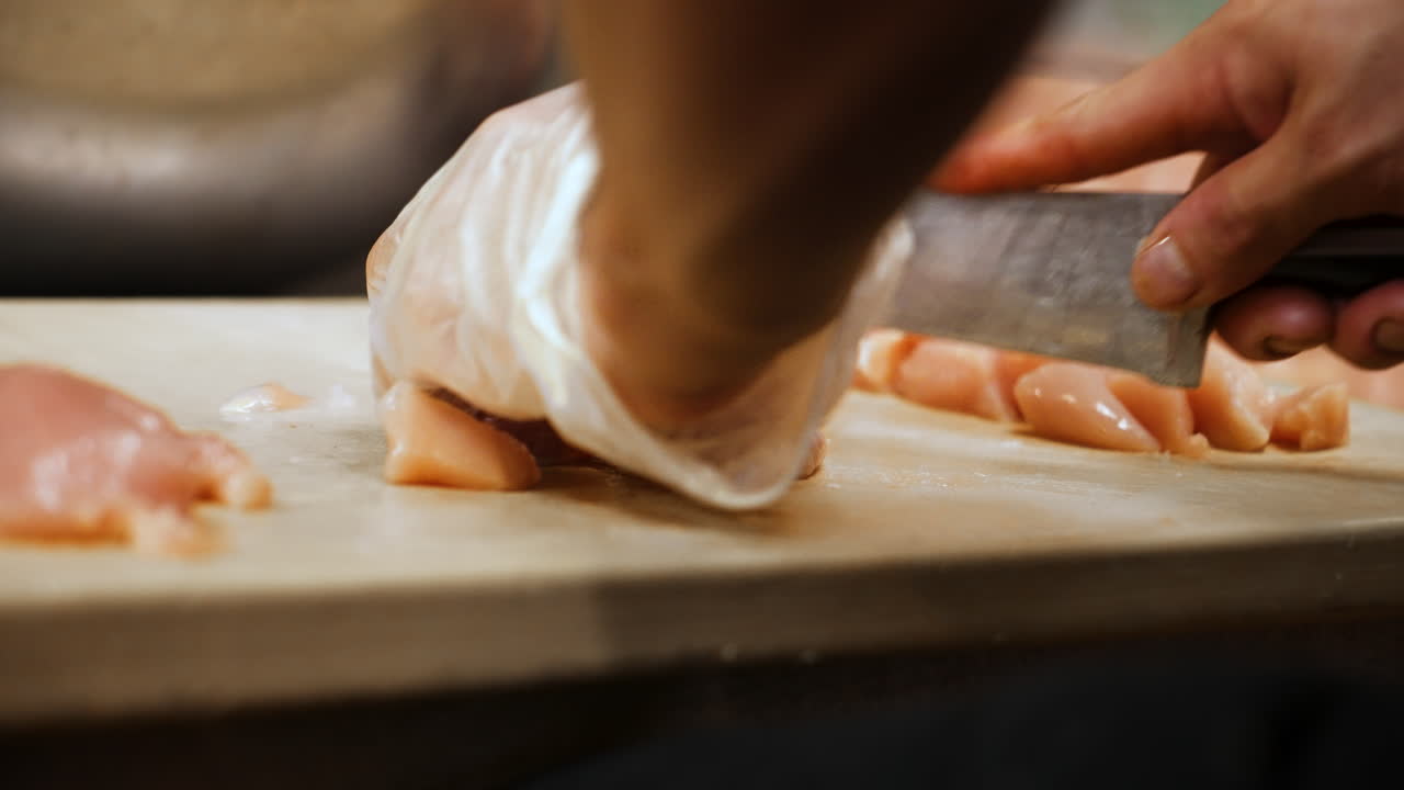 grandes cuchillos de chef cortan trozos de carne de pechuga de pollo cruda, cámara lenta de cerca 4k