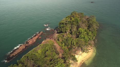 aerial birds eye view of backwards flying drone looking down on uninhabited tropical island