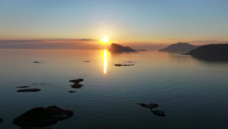 midnight sun and calm sea, serene summer night, in northern norway - aerial view