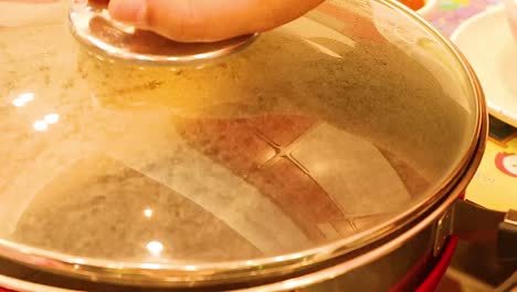 a sequence showing the process of covering a hot pot with a lid to begin simmering.