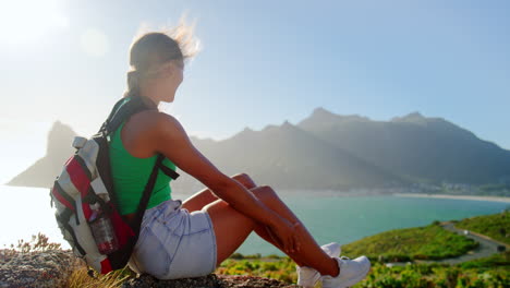 retrato de una mujer con una mochila de vacaciones tomando un descanso en una caminata por el mar en el camino costero