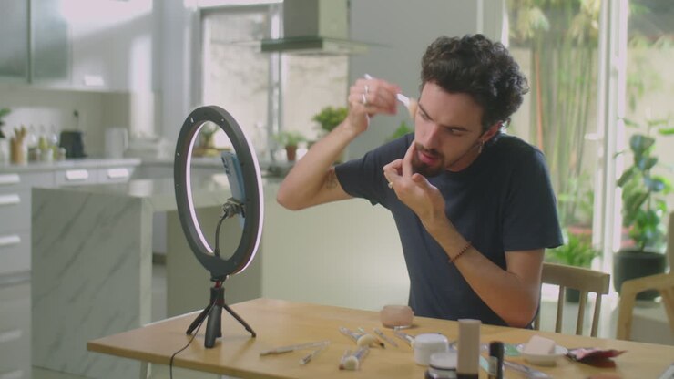 Beauty blogger uomo che filma un tutorial di make-up a casa