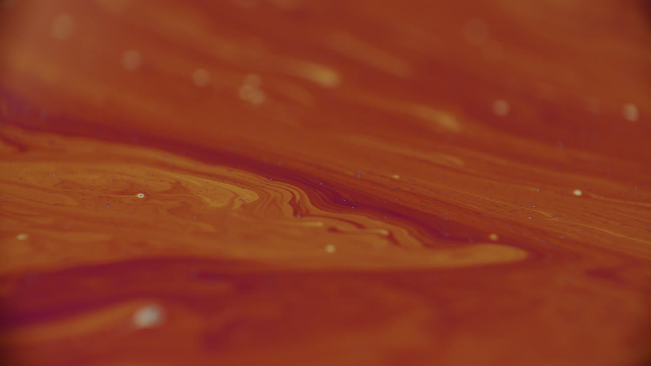 진한 주황색에서 밝은 주황색으로 색상이 바뀌는 점성 액체의 슬로우 모션 샷