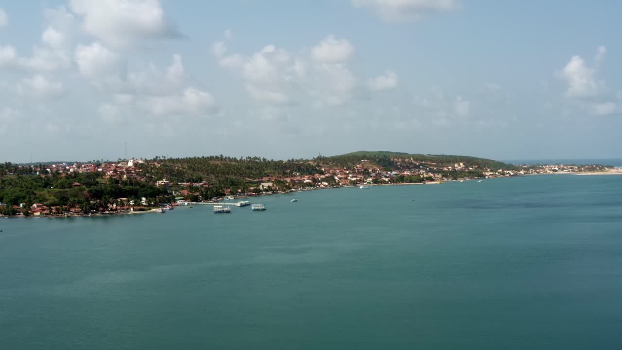 panorámica izquierda drone aéreo amplia toma de paisaje de la playa tropical de la ciudad de barra do cunhaú en canguaretama donde el gran río curimataú se encuentra con el mar en el estado de rio grande do norte, brasil