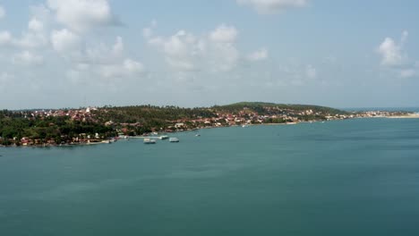 panorámica izquierda drone aéreo amplia toma de paisaje de la playa tropical de la ciudad de barra do cunhaú en canguaretama donde el gran río curimataú se encuentra con el mar en el estado de rio grande do norte, brasil