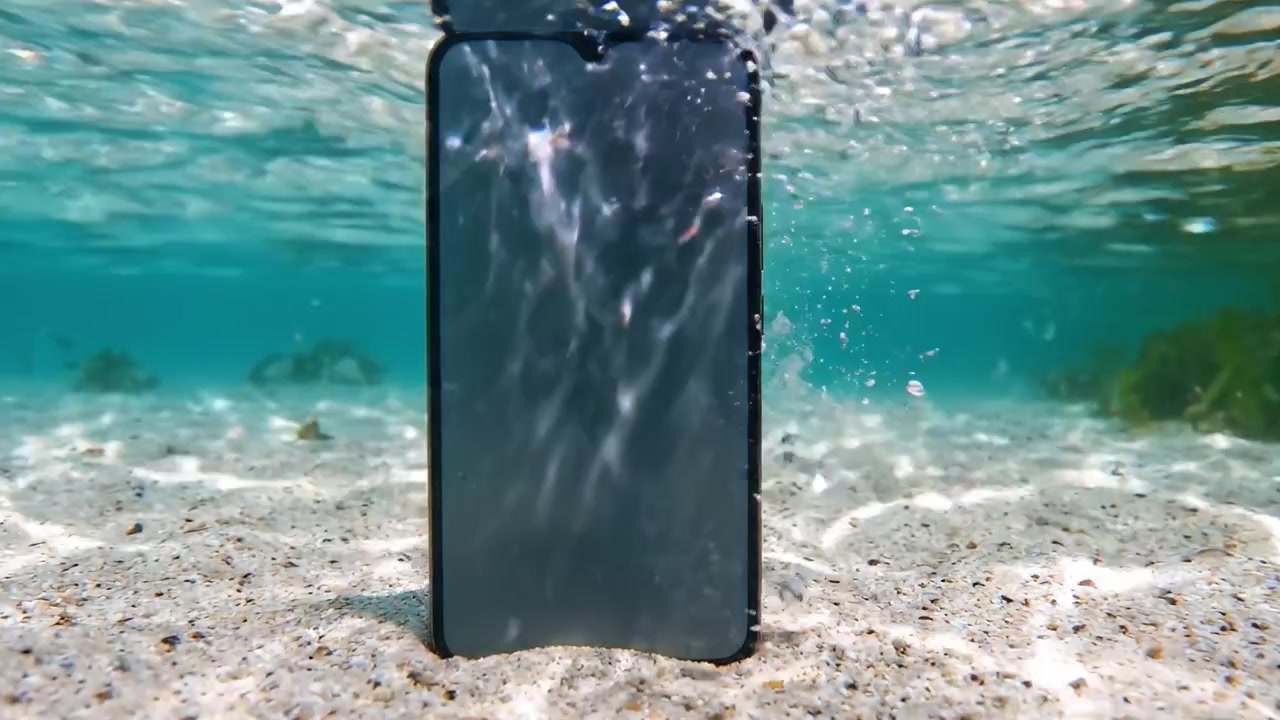 A Mobile Phone Positioned Underwater, Surrounded by Sandy Substrate and Clear Water, Capturing Attention with its Unique Setting and Reflective Surface