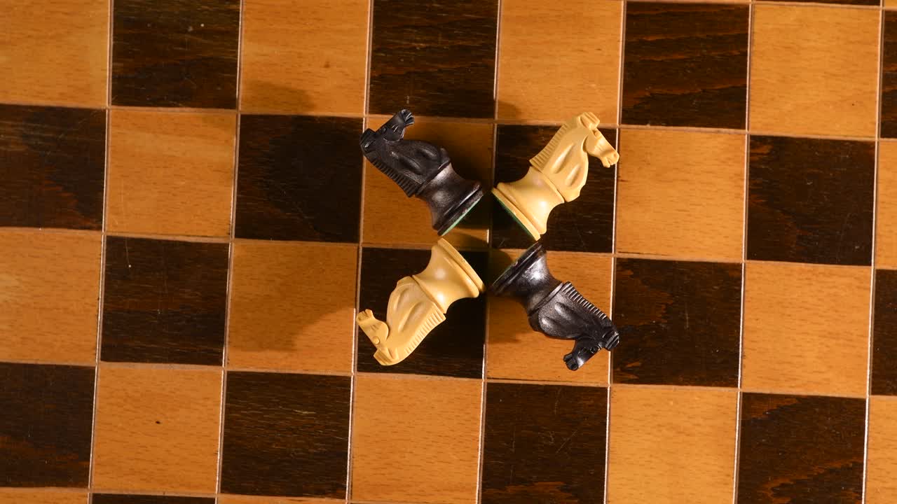 caballeros oponentes iguales, todos derribados en el tablero de ajedrez