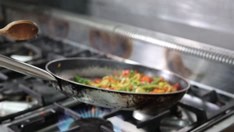 Mixing-sliced-vegetable-in-a-frying-pan,-close-up,-4k-footage