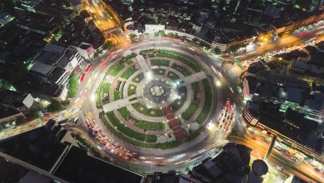 time-lapse or hyper-lapse aerial view 4 way road roundabout circle or intersection traffic at night for transportation concept.