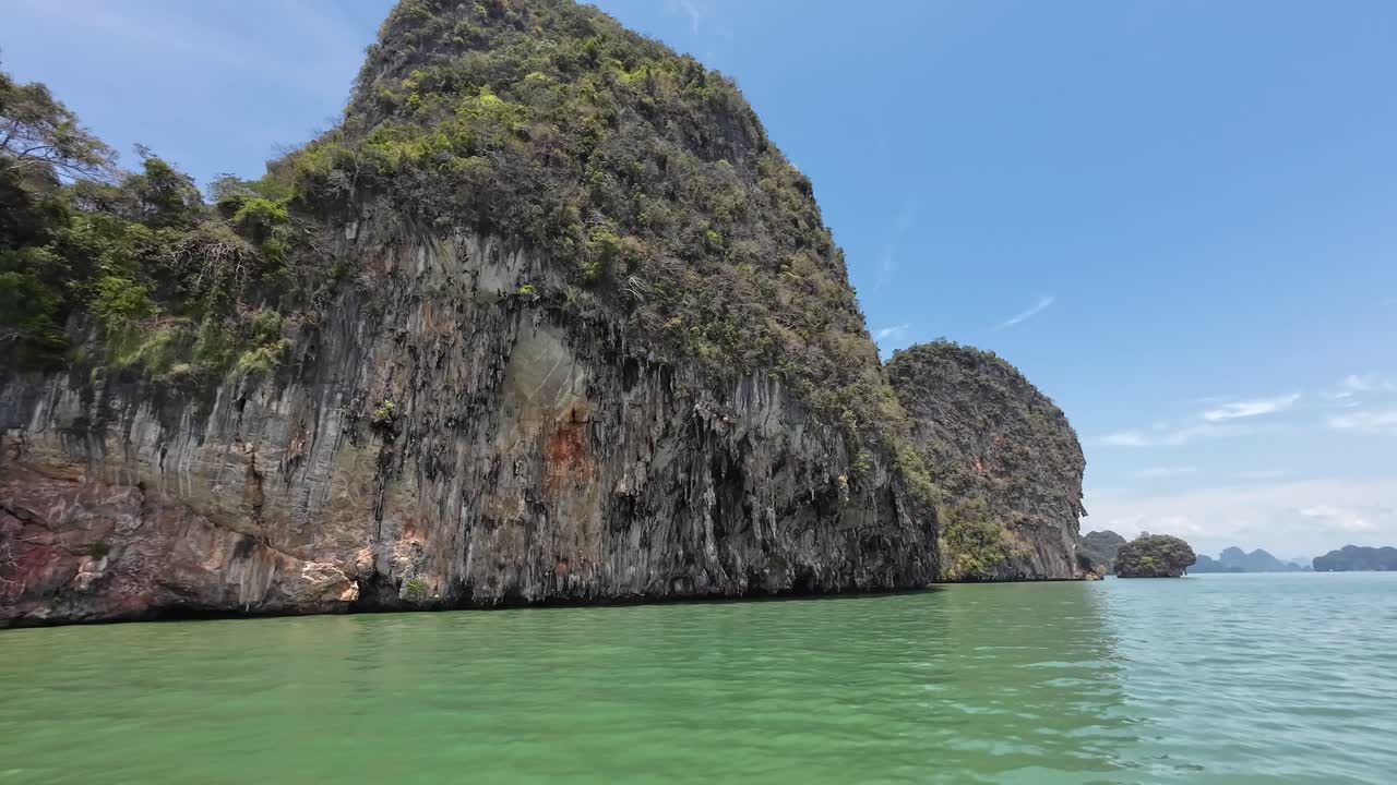 Một chuyến đi thuyền ngắm cảnh qua những vách đá vôi cao chót vót ở Vịnh Phang Nga, Phuket, Thái Lan, với làn nước nhiệt đới, các khối đá karst hùng vĩ và là một điểm đến du lịch nổi tiếng