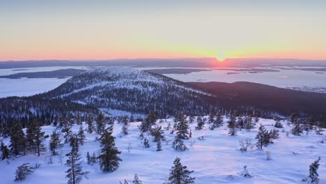 puesta de sol romántica sobre colinas y valles nevados de la región escandinava