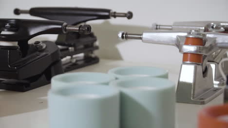 close up skateboard parts, trucks, wheels, bearings on white desk