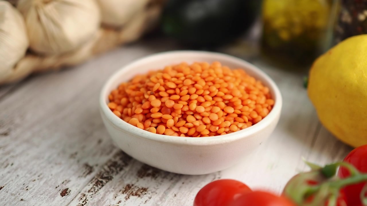 Bol de lentilles corail sur une table de cuisine rustique