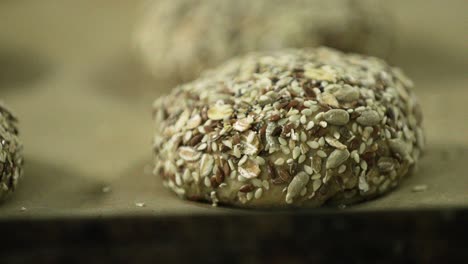 hamburger bread dough loaded with seeds on a baking tray