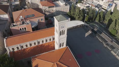 Aerial-orbits-clock-tower-of-Franciscan-Convent,-museum-in-Nazareth-ISR