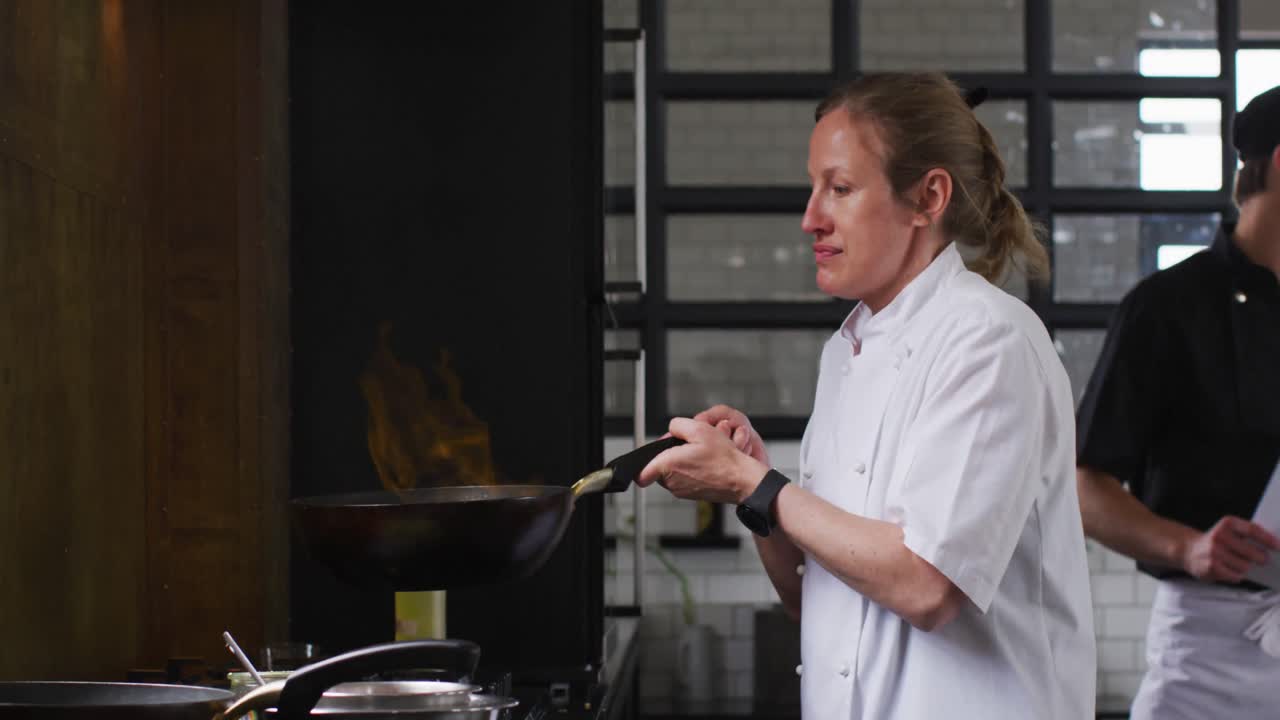 cocinera caucásica enseñando a un grupo diverso preparando platos y sonriendo