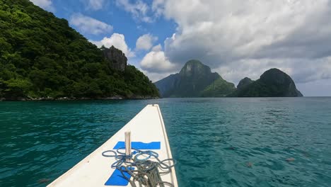 Traveling-on-boat-approaching-remote-tropical-islands-on-turquoise-ocean-water-in-El-Nido,-Palawan,-Philippines,-Southeast-Asia