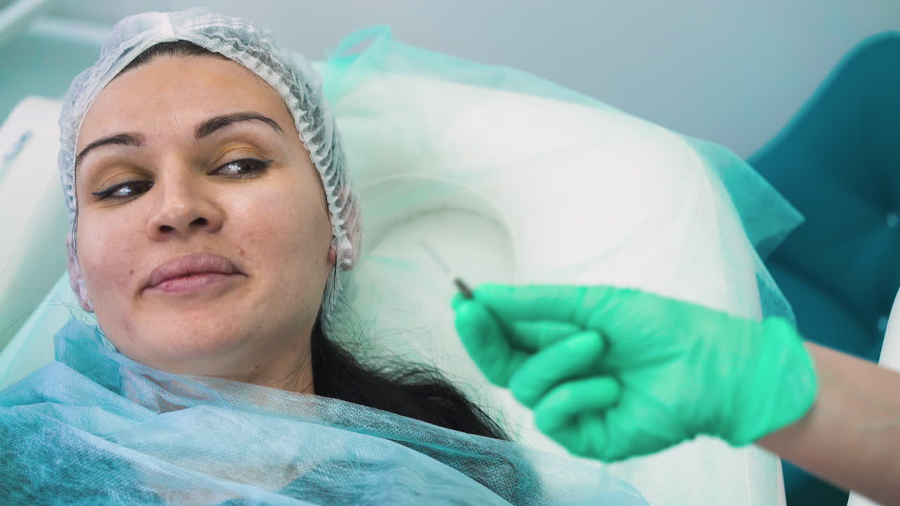 el cosmetólogo muestra la aguja para la inyección de relleno al cliente