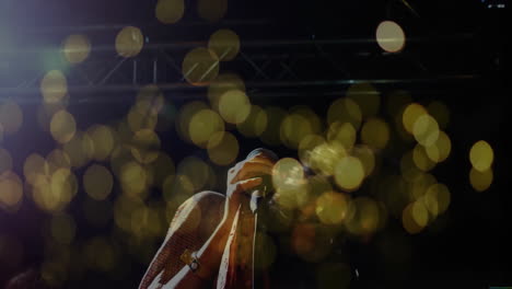 female singer with microphone performing on stage for music ads with floating bokeh, animated waves